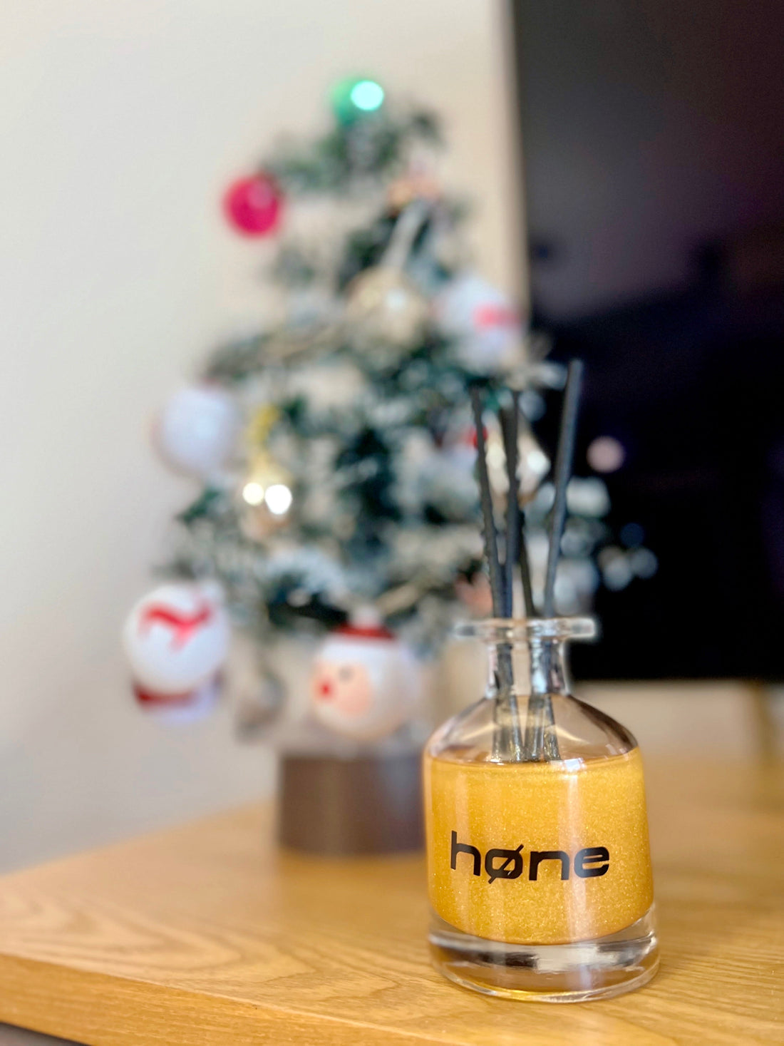 Hone Aroma Lime and Basil 70ml Reed Diffuser in Gold next to Christmas Tree