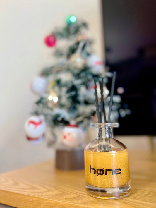 Hone Aroma Lime and Basil 70ml Reed Diffuser in Gold next to Christmas Tree